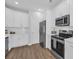 Stylish kitchen featuring white cabinets, stainless steel appliances, and wood-look flooring at 5132 Little River Neck Rd., North Myrtle Beach, SC 29582