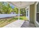 Covered patio with wood-look tile overlooks the fenced backyard and lush green space at 5132 Little River Neck Rd., North Myrtle Beach, SC 29582