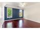 Spacious bedroom with hardwood floors, two large windows, and a calming blue accent wall at 2934 Midiron Ct., Myrtle Beach, SC 29577
