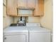 This laundry room features a Whirlpool washer and dryer, and upper wooden cabinets for storage at 2934 Midiron Ct., Myrtle Beach, SC 29577
