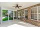 Covered patio with brick accents, tiled floors, ceiling fan, and a wall of large windows at 2934 Midiron Ct., Myrtle Beach, SC 29577