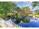 Scenic pond view with a white picket fence, mature trees, and building in the background at 2934 Midiron Ct., Myrtle Beach, SC 29577