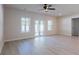 Bright living room featuring modern flooring, neutral walls, and a ceiling fan with direct access to outdoor living at 549 Honeyhill Loop, Conway, SC 29526