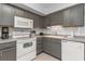 Cozy kitchen with modern appliances, including gray cabinets and white appliances at 5600 North Ocean Blvd. # B-3, North Myrtle Beach, SC 29582
