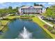 Aerial view of condo building with a well-maintained lawn and a pond with a fountain feature at 5750 Oyster Catcher Dr. # 1135, North Myrtle Beach, SC 29582