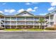 Beautiful condo with three levels, stairways, white railings, and well-maintained landscaping at 5750 Oyster Catcher Dr. # 1135, North Myrtle Beach, SC 29582