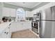 Bright kitchen equipped with stainless steel appliances, white cabinets, and a large window above the sink for added light at 5750 Oyster Catcher Dr. # 1135, North Myrtle Beach, SC 29582