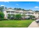 Beautiful condos with green lawns and white porches nestled among mature trees at 5825 Catalina Dr. # 1034, North Myrtle Beach, SC 29582
