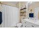 Well-lit bathroom with a white shower curtain, vanity and mirror complemented by decorative shelves and accents at 6015 Catalina Dr. # 132, North Myrtle Beach, SC 29582