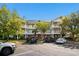 Exterior view of a three-story condo building with white balconies, lush landscaping, and ample parking at 6015 Catalina Dr. # 132, North Myrtle Beach, SC 29582