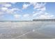 Expansive beach view featuring a pier in the distance and gentle waves under a partly cloudy sky at 6100 N Ocean Blvd. # 804, North Myrtle Beach, SC 29582
