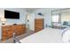 Bright bedroom with wood dressers, a TV, and a mirrored closet showcasing neutral tones and relaxing decor at 6100 N Ocean Blvd. # 804, North Myrtle Beach, SC 29582
