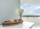 Close-up on neutral-toned decor sitting on a table with a view of the ocean from the window at 6100 N Ocean Blvd. # 804, North Myrtle Beach, SC 29582
