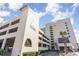 Exterior of a condo building with a parking garage and lush landscaping on a sunny day with blue skies at 6100 N Ocean Blvd. # 804, North Myrtle Beach, SC 29582