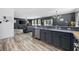 Kitchen with stainless steel appliances and gray cabinets flowing into the living room at 650 Woodman Dr., Conway, SC 29526