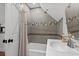 Compact bathroom features a gray-tiled shower-tub combo and a sink with modern fixtures at 710 Yucca Ave., Myrtle Beach, SC 29577