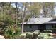 A charming single-story home with a gray exterior, surrounded by lush greenery and mature trees at 880 Briarwood Dr., Myrtle Beach, SC 29572