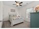 Cozy bedroom featuring light walls, a ceiling fan, and a white bedframe and colorful bedding with an ocean motif at 948 Jackline Place # 201, Murrells Inlet, SC 29576