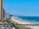Picturesque oceanfront view showcasing a sandy beach, pier, and the sparkling Atlantic Ocean at 9650 Shore Dr. # 810, Myrtle Beach, SC 29572