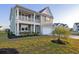Inviting two-story home with a spacious front yard and charming double stacked porch at 101 Cowan Pl., Myrtle Beach, SC 29588