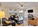 Comfortable living room with a ceiling fan, decorative fireplace and mantle with large windows to the outdoor patio at 101 Cowan Pl., Myrtle Beach, SC 29588