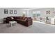 Spacious living room with plush carpeting, a large brown sectional, and ample natural light at 101 Cowan Pl., Myrtle Beach, SC 29588