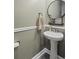 Neat powder room featuring a pedestal sink, round mirror, and decor at 101 Cowan Pl., Myrtle Beach, SC 29588