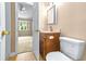 Bathroom with wood vanity, decorative mirror, and gold fixtures; bedroom visible through doorway at 1516 Saint George Ln., Myrtle Beach, SC 29588
