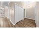 Hallway with hardwood floors features storage closet, chandelier, and neutral walls at 1516 Saint George Ln., Myrtle Beach, SC 29588
