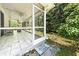 Entrance to screened porch with tiled floors and a tranquil backyard view, enhanced by a welcoming 'Home Sweet Home' mat at 1516 Saint George Ln., Myrtle Beach, SC 29588