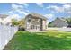 Backyard with an attached home featuring green grass, an open patio, and a white fence at 237 Chesapeake Ln., Murrells Inlet, SC 29576