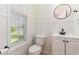 This half-bath features white wainscoting, black fixtures, a round mirror and a window at 237 Chesapeake Ln., Murrells Inlet, SC 29576