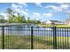 Scenic view of a pond, with green grass, a black fence, and a home in the background at 237 Chesapeake Ln., Murrells Inlet, SC 29576