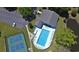 Aerial view of a community pool, tennis courts, and parking lot surrounded by lush greenery at 2488 Oriole Dr., Murrells Inlet, SC 29576