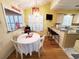 Cozy dining area with bright windows, chandelier, and breakfast bar in the background at 2488 Oriole Dr., Murrells Inlet, SC 29576
