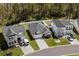 Aerial view showcasing multiple houses in a well manicured neighborhood with tall trees in the background at 255 Augusta Green Way, Myrtle Beach, SC 29579