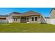 Back exterior view of home featuring the screened porch and well-maintained lawn at 255 Augusta Green Way, Myrtle Beach, SC 29579