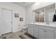 Well-lit bathroom featuring a double sink vanity, toilet, and large mirror with a view of the tiled shower at 255 Augusta Green Way, Myrtle Beach, SC 29579