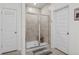 Tiled shower with glass door and bench; also features a convenient door and a patterned rug in the bathroom at 255 Augusta Green Way, Myrtle Beach, SC 29579
