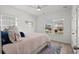Bright bedroom featuring neutral bedding, ceiling fan, wood-look flooring and a view of the neighborhood at 255 Augusta Green Way, Myrtle Beach, SC 29579