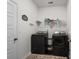 Functional laundry room equipped with black washer and dryer, ample shelving, and decorative wall art at 255 Augusta Green Way, Myrtle Beach, SC 29579