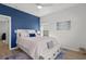 Cozy bedroom with a blue accent wall, light pink bedding, ceiling fan and wood-look flooring at 255 Augusta Green Way, Myrtle Beach, SC 29579