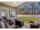 Screened-in porch with a fire pit, seating, and view of the backyard at 255 Augusta Green Way, Myrtle Beach, SC 29579
