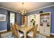 Dining room featuring blue walls, wood floors, chandelier, and view into the kitchen at 273 Golden Bear Dr. # F3, Pawleys Island, SC 29585