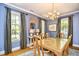 Stylish dining room with blue walls, chandelier, and large windows at 273 Golden Bear Dr. # F3, Pawleys Island, SC 29585