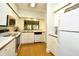 Well-lit kitchen featuring white cabinets, wood-look flooring, and a view through a pass-through window at 273 Golden Bear Dr. # F3, Pawleys Island, SC 29585