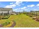 A large fenced backyard with green grass, a storage shed, and a swing set at 296 Switchgrass Loop, Little River, SC 29566