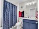 Bathroom featuring blue vanity, shower with anchor curtain, and nautical decor at 296 Switchgrass Loop, Little River, SC 29566