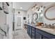 Well-lit bathroom featuring double vanity, decorative mirrors, and a tiled walk-in shower at 296 Switchgrass Loop, Little River, SC 29566