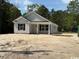Charming single-story home with light gray siding, black shutters, and a welcoming front porch in a serene, wooded setting at 2991 Inheritance Rd., Conway, SC 29527